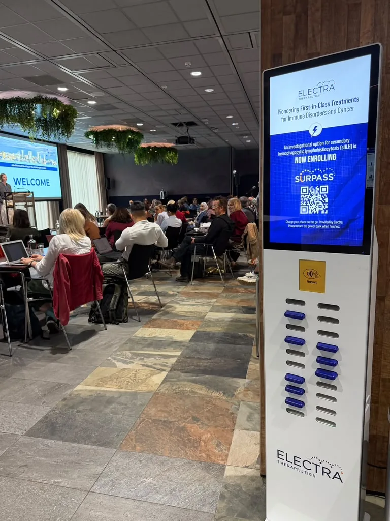 Branded oplaadzuil met powerbanks en scherm tijdens een congres
