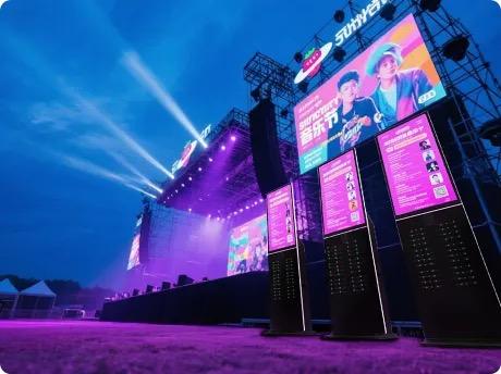 Powbank oplaadstations op groot festival met duizenden bezoekers, podiumverlichting en festivalsfeer - professionele oplaadinfrastructuur voor evenementen
